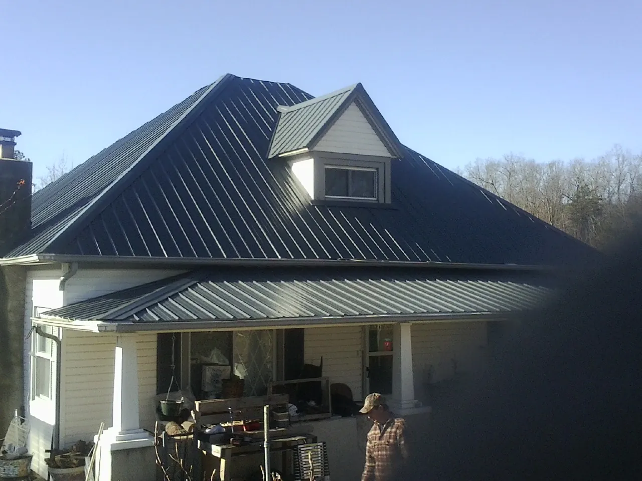 Dark blue standing seam metal roof with a dormer above a front porch in Warminster