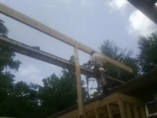 Carpenter setting a ridge beam over a new addition frame — Ice Dam Removal by Roofing Brothers in Warminster