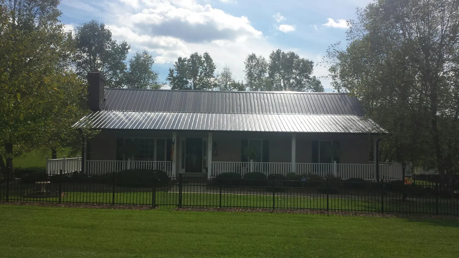 Gray metal roof on a brick ranch with a full width front porch — Gutter Guard Installation work by our crew in Warminster