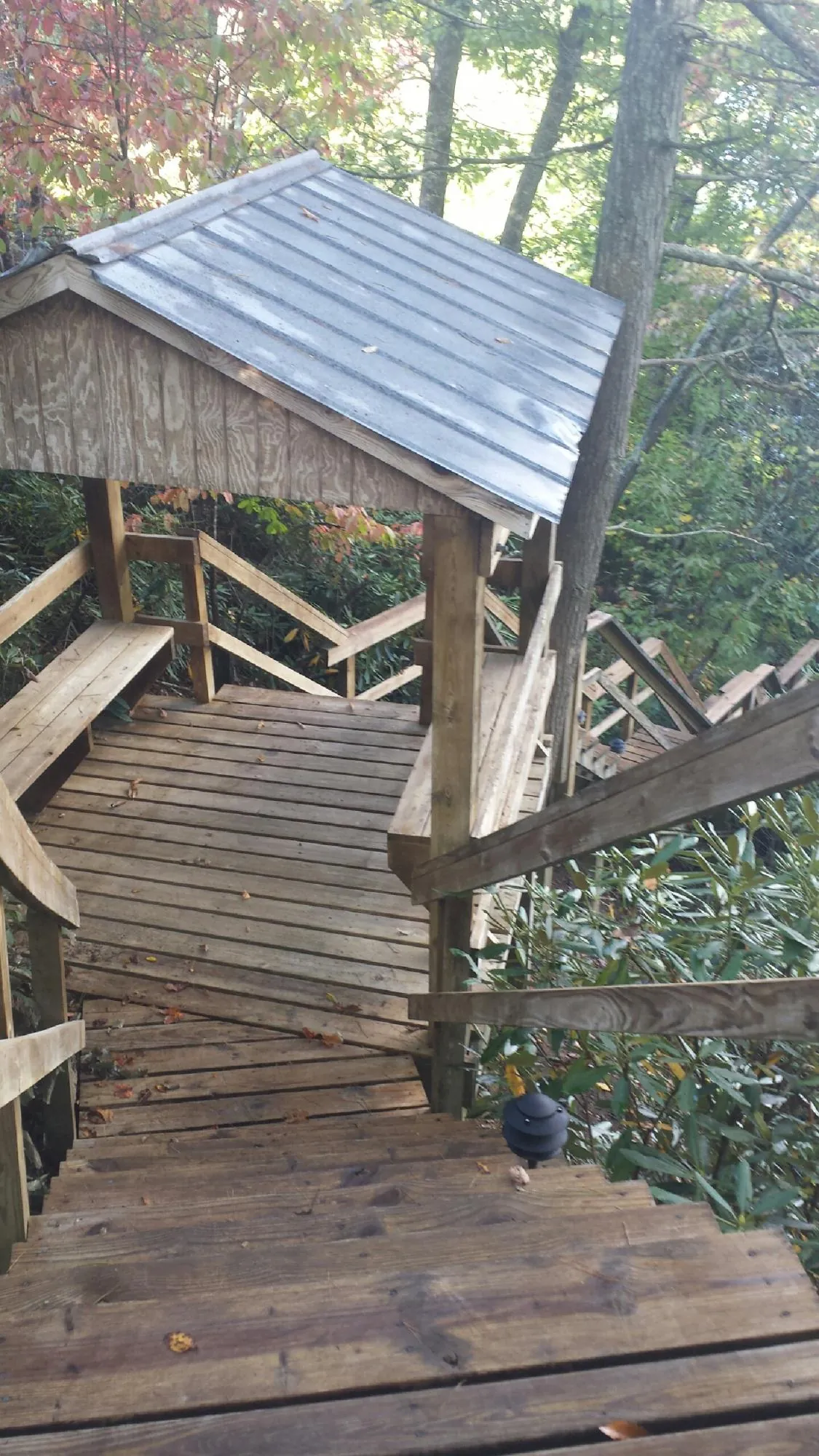 Metal roofed shelter over wooden steps on a wooded walkway — Skylight Repair & Installation work by our crew in Warminster