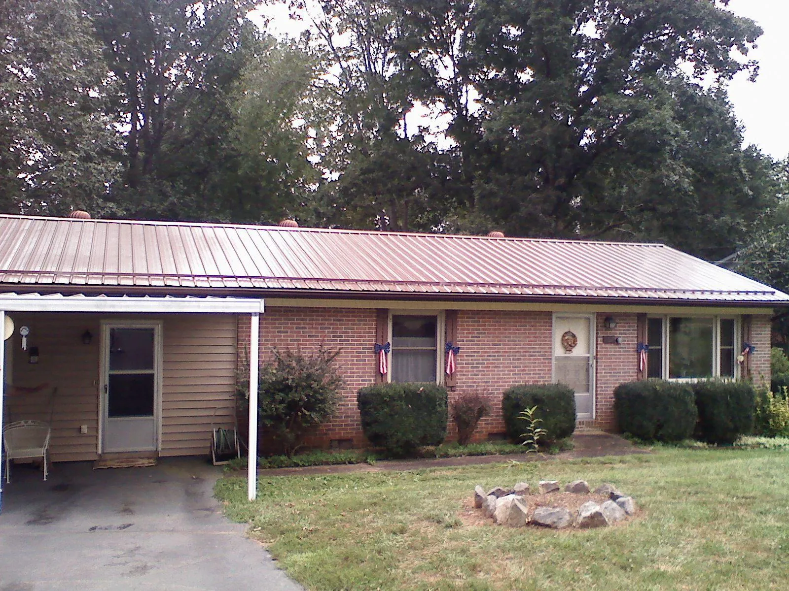 Bronze metal roof and carport on a brick ranch home — Roof Repair work by our crew in Warminster